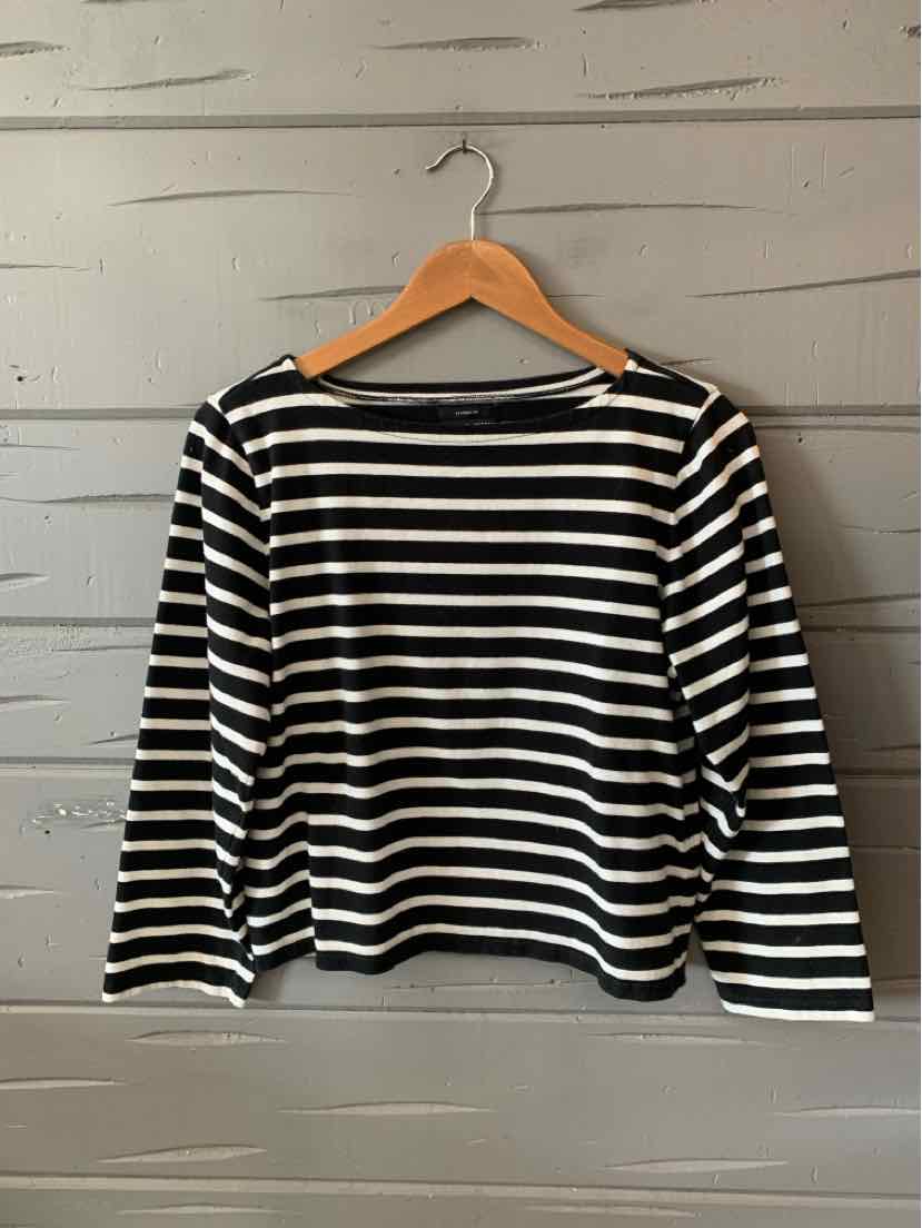 Black and white horizontal striped long-sleeve boat neck shirt on wooden hanger.