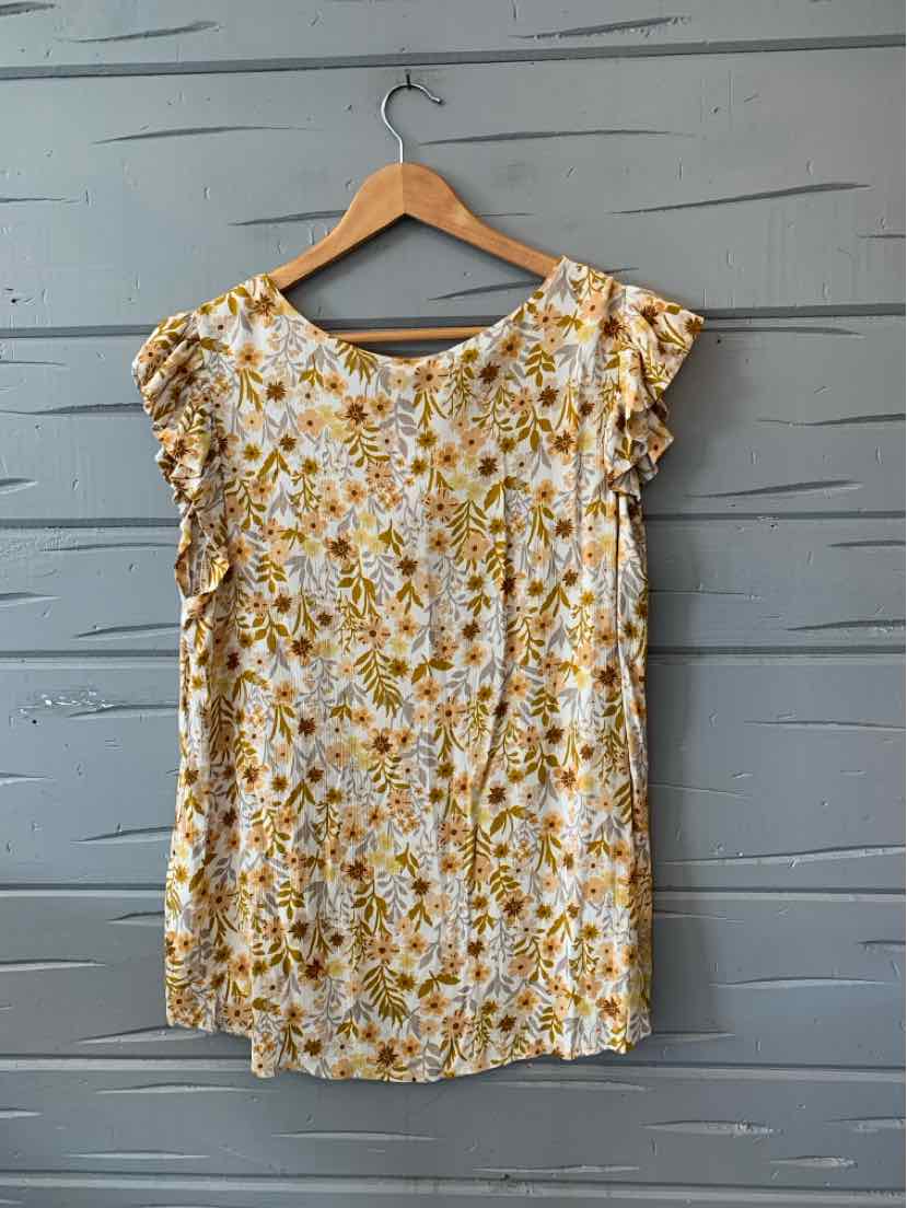 White floral blouse with yellow and green flower print, ruffled short sleeves, and round neckline.