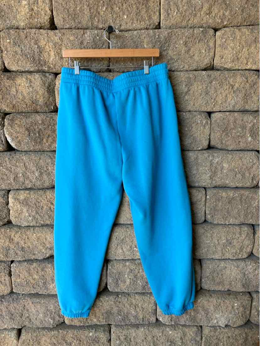 Bright blue Under Armour sweatpants with a relaxed fit, elastic cuffs, and a drawstring waist.