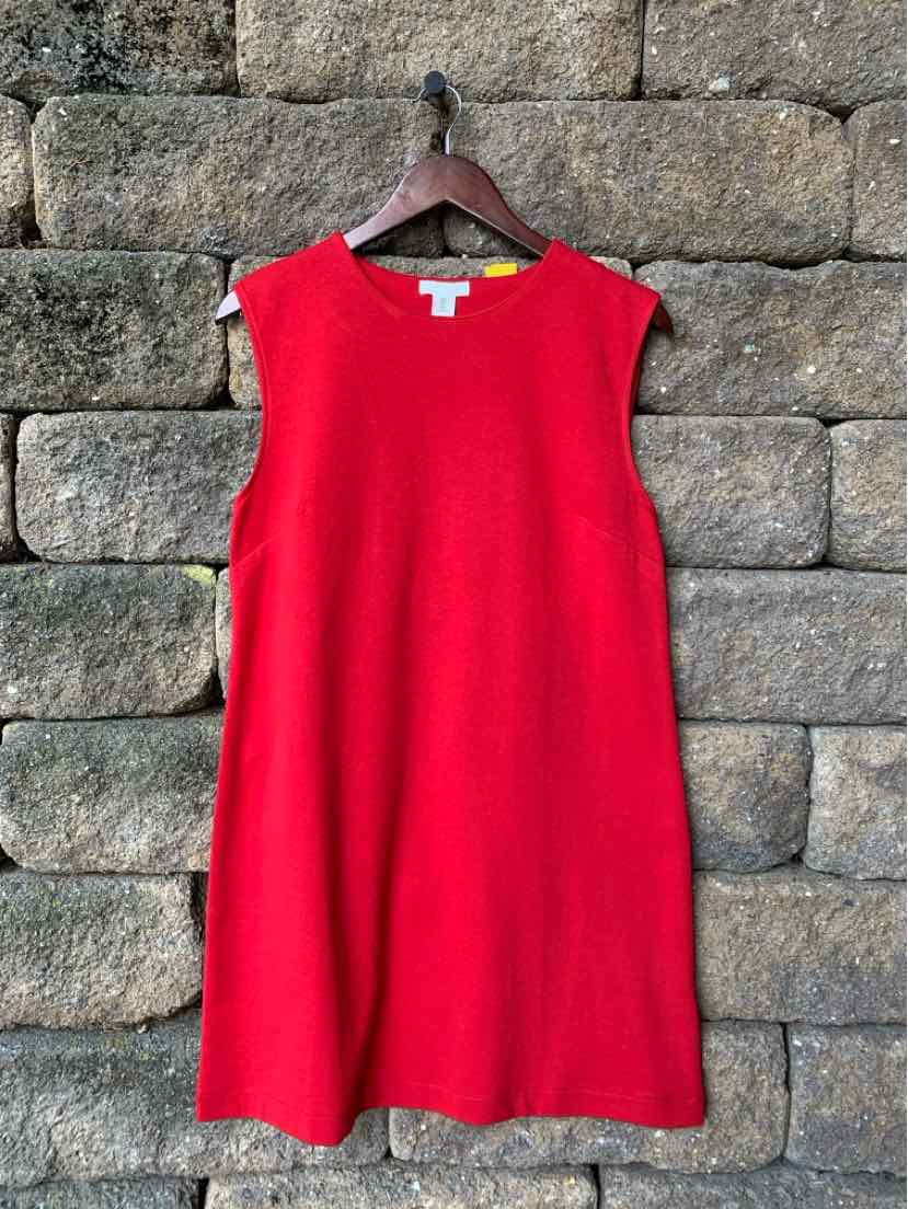 Sleeveless red knee-length dress with round neckline, solid color, hanging on wooden hanger.