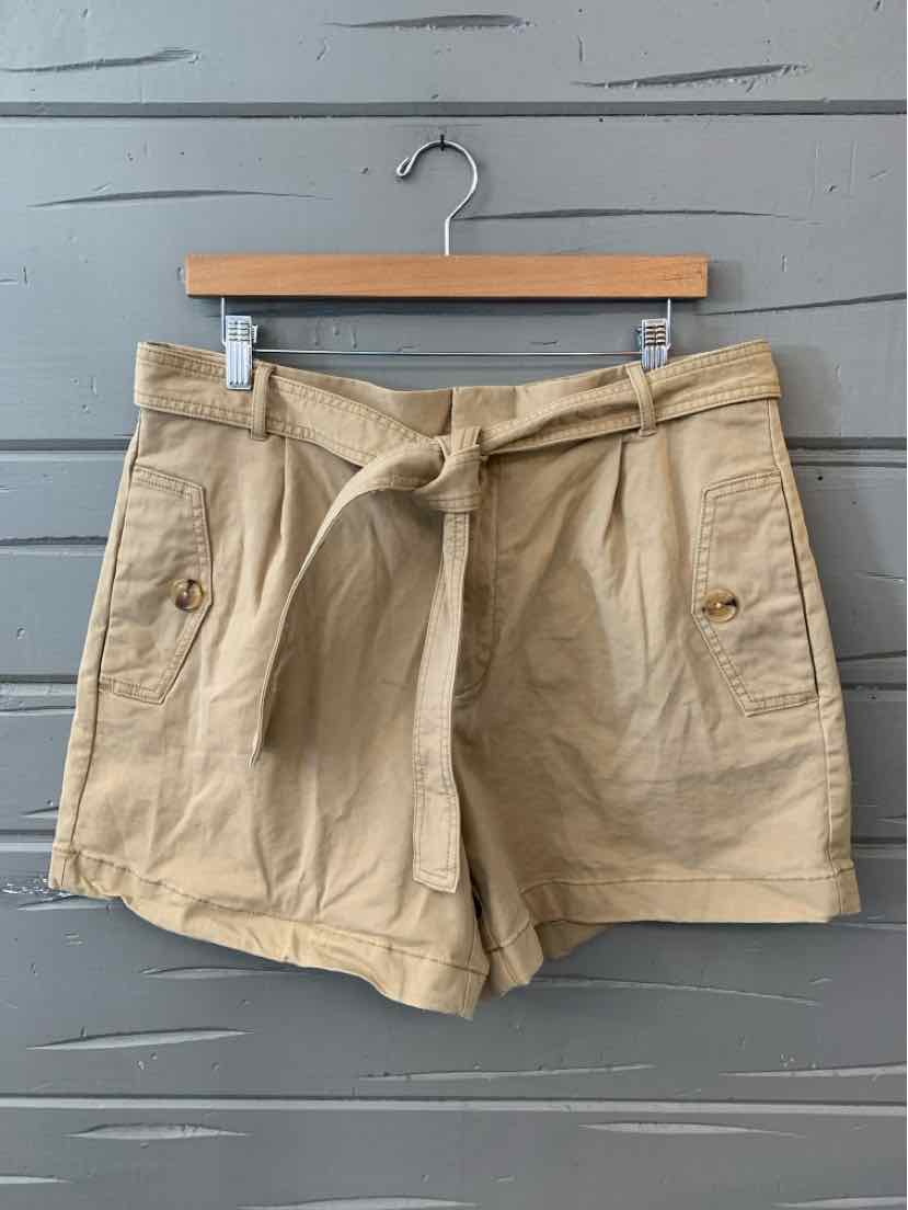 Khaki high-waisted shorts with front patch pockets and self-tie belt on wooden hanger.