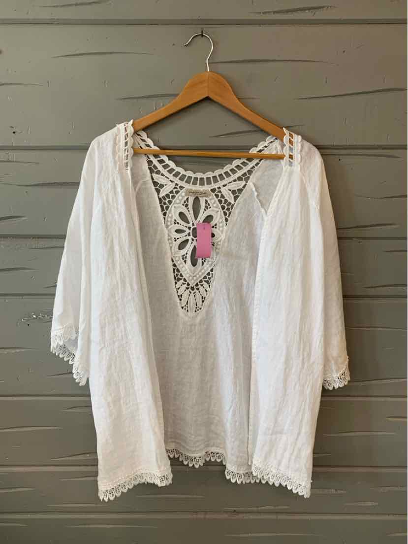 White bohemian-style blouse with crochet lace detailing at the neckline and sleeves, lightweight fabric with loose fit.