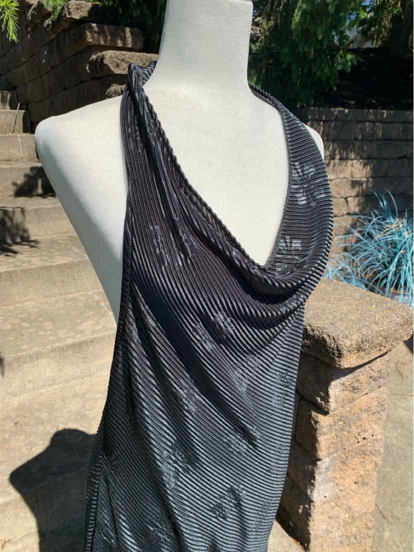 Black sleeveless draped cowl neck top with subtle striped texture on mannequin outdoors.