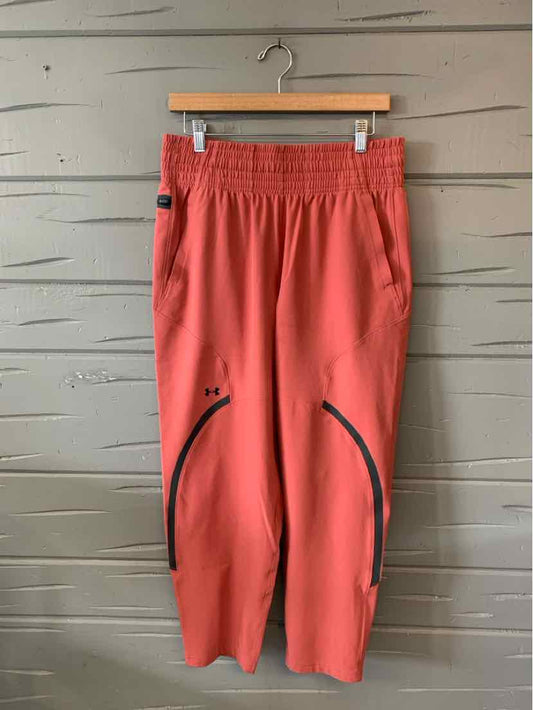 Coral red athletic pants with elastic waistband and zippered side pockets, medium size.