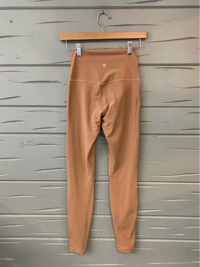 High-waisted tan leggings with a smooth, stretchy fabric and flatlock seams.