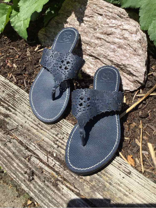 Black leather thong sandals with perforated floral cutouts and cushioned footbeds, size 6.