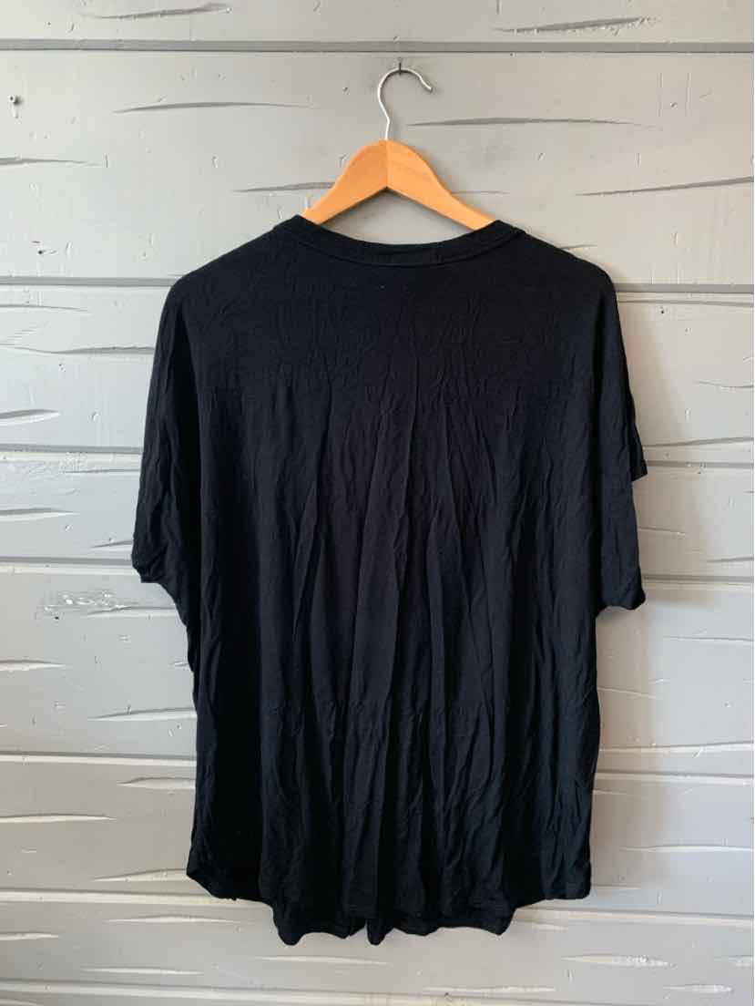 Black short-sleeve oversized T-shirt in size L/XL hanging on wooden hanger.