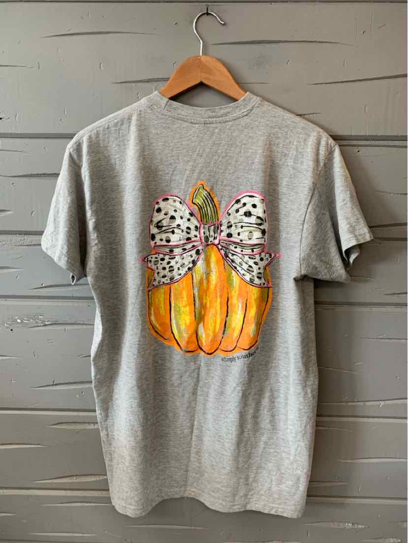 Light gray short-sleeve tee with graphic of orange pumpkin topped with large white bow featuring black polka dots.