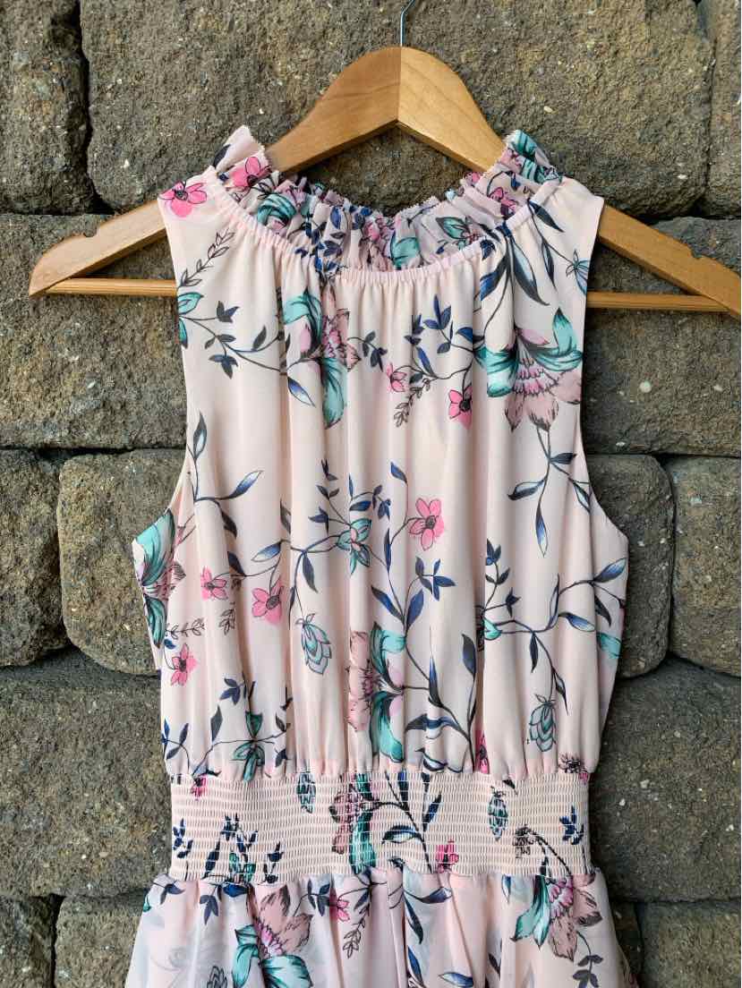 Sleeveless pink dress with floral print, ruffled neckline, and smocked waist detail.