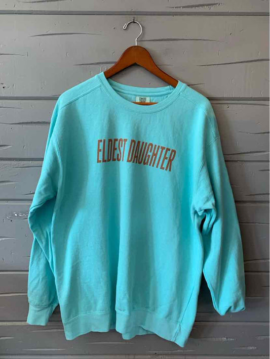 Teal crewneck sweatshirt with "ELDEST DAUGHTER" printed in beige on front, relaxed fit.