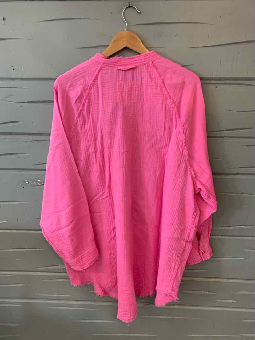 Bright pink long-sleeve lightweight blouse with relaxed fit hanging on wooden hanger.