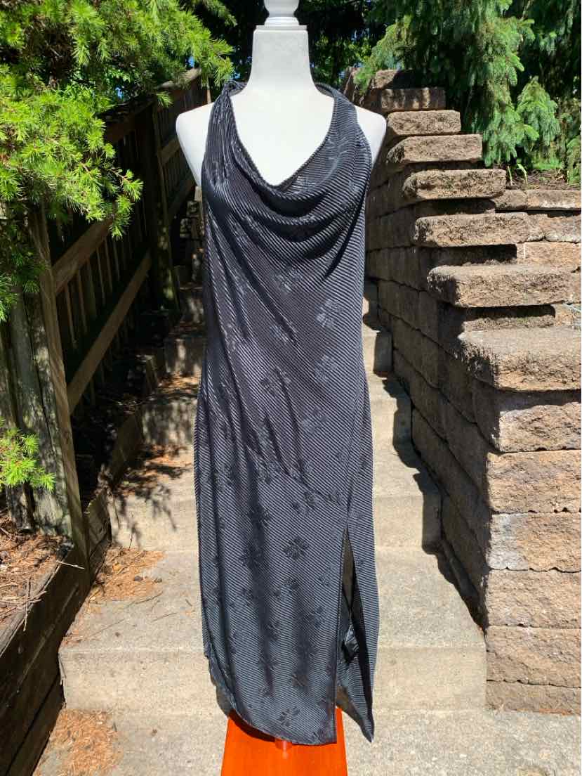 Black sleeveless satin slip dress with cowl neck and side slit on mannequin outdoors.