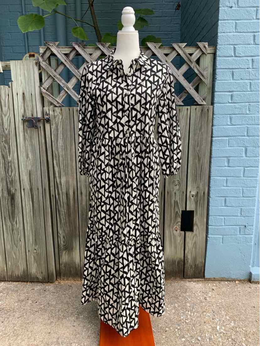 Black and white geometric long-sleeve midi dress with button-up front and collar.