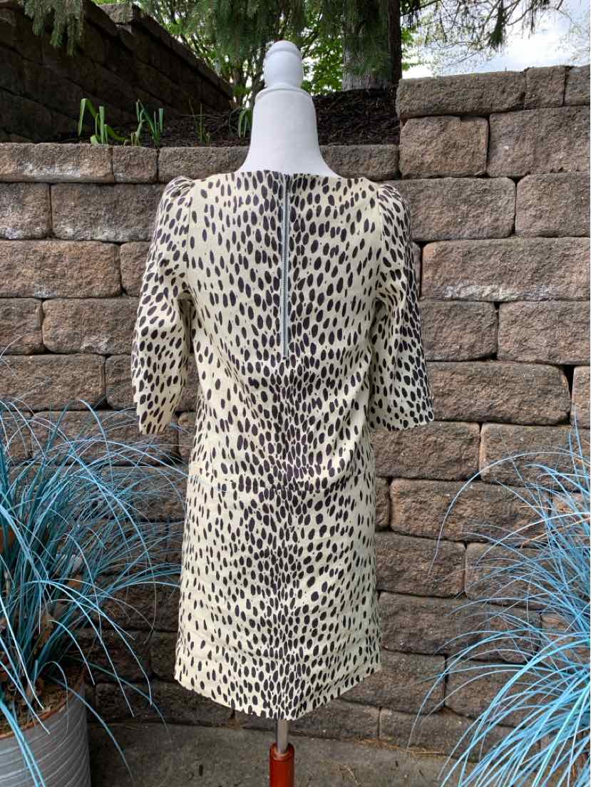 Animal print dress with short puff sleeves and a back zipper, fitted silhouette in black and cream.