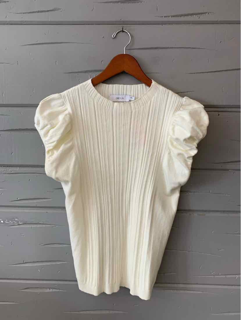 Cream-colored knit top with vertical ribbing and puffed short sleeves on wooden hanger.