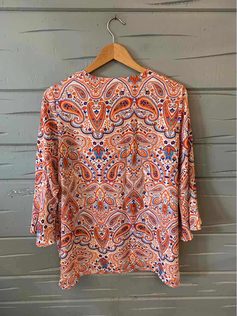 Orange paisley long-sleeve blouse with blue and white accents, size 1X, hanging on wooden hanger.