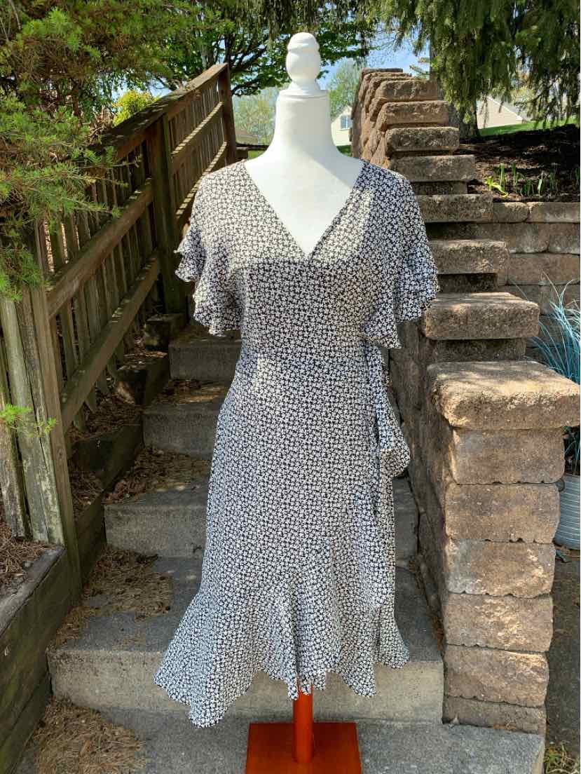 Black floral maxi dress with V-neck and flutter sleeves on mannequin outdoors.
