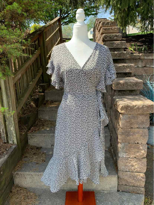 Black floral maxi dress with V-neck and flutter sleeves on mannequin outdoors.