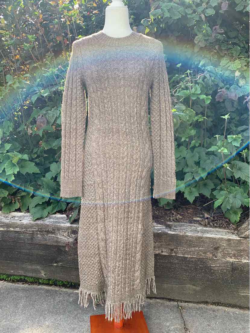 Beige ribbed knit midi dress with long sleeves and fringe hem detail.