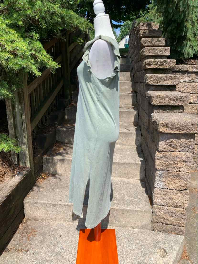 Light green sleeveless dress with scoop neckline and side slits on mannequin outdoors.