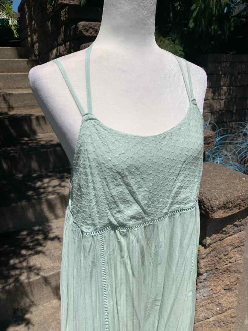Light mint green sleeveless dress with thin straps and textured fabric detailing.