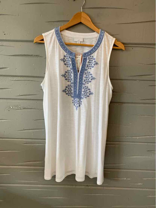 White sleeveless tunic with blue embroidered floral pattern around scoop neckline and front placket.