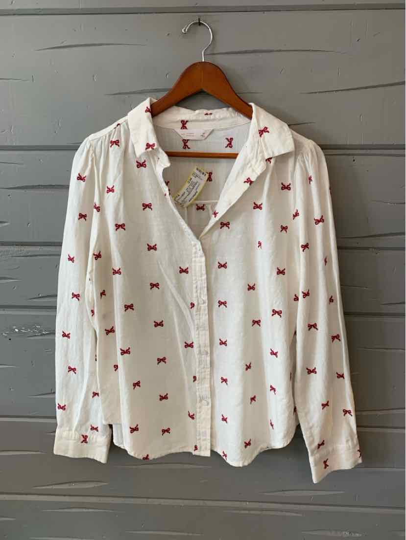 White button-up blouse with red bow patterns, long sleeves, and a relaxed fit.