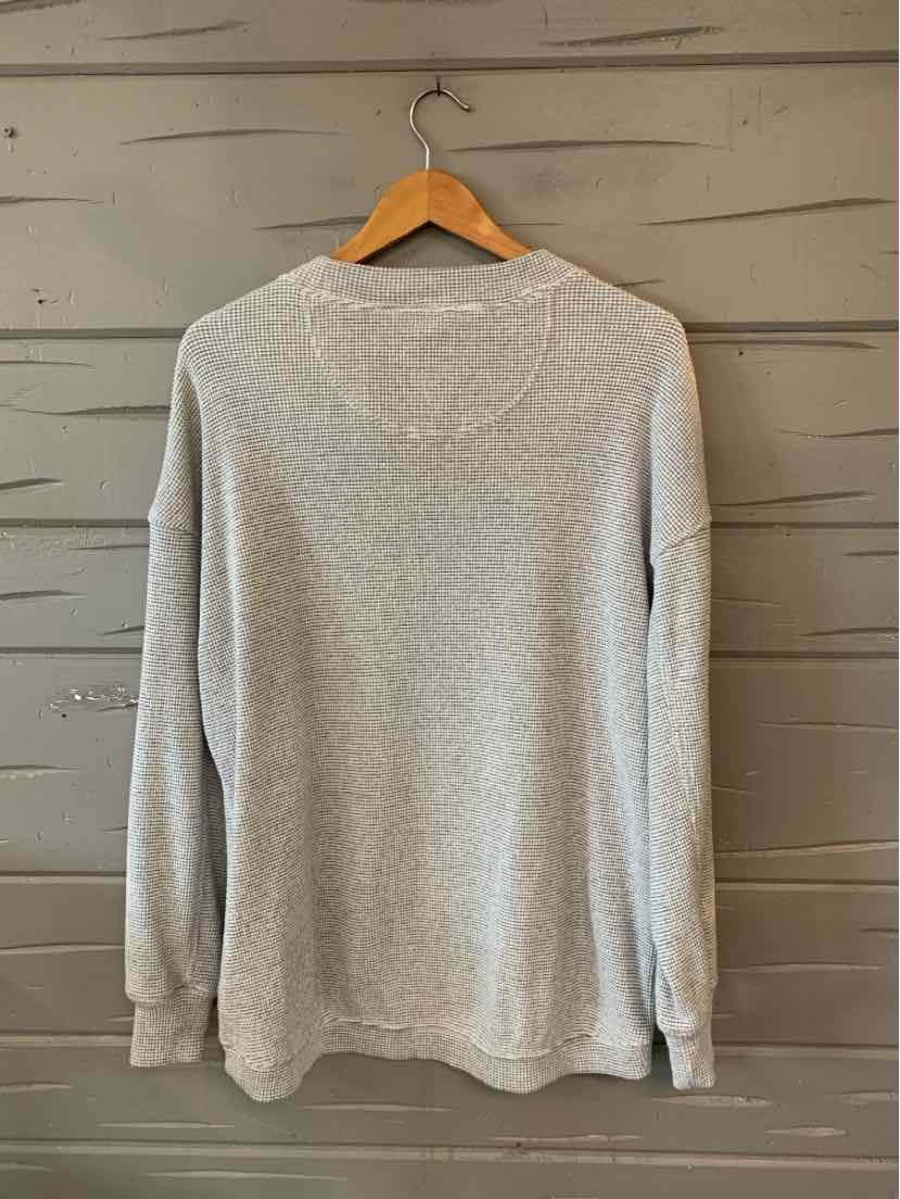 Light gray long-sleeve crewneck sweatshirt with ribbed cuffs and hem, hanging on wooden hanger.