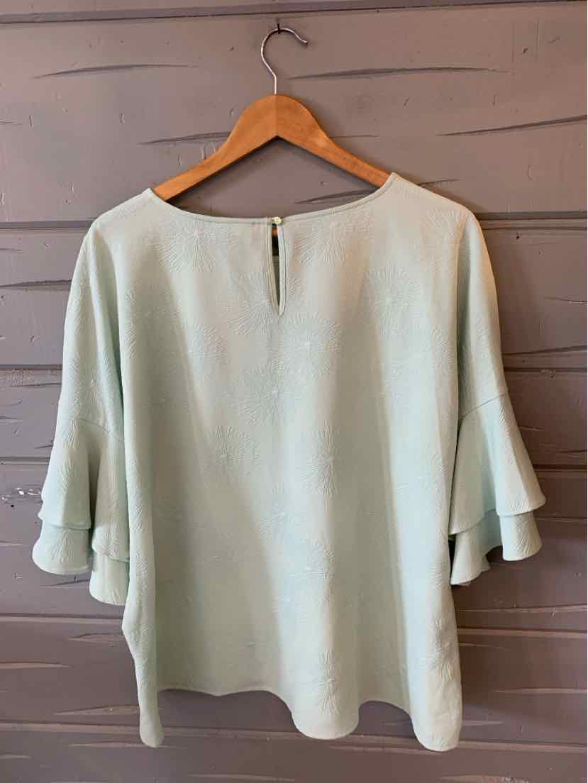 Light green blouse with round neckline, keyhole back button, and layered bell sleeves.
