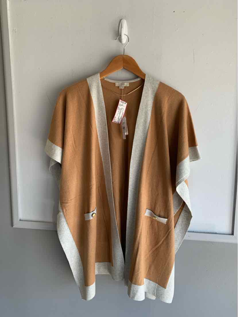 Camel and cream open-front knit cardigan with short sleeves and front pockets hanging on a white wall hook.