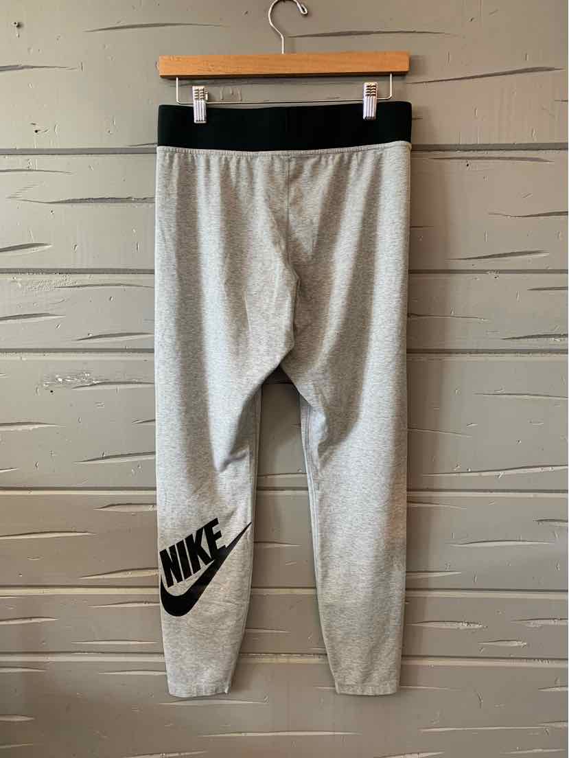 Light gray Nike jogger pants with black waistband and black logo on left leg, size large.