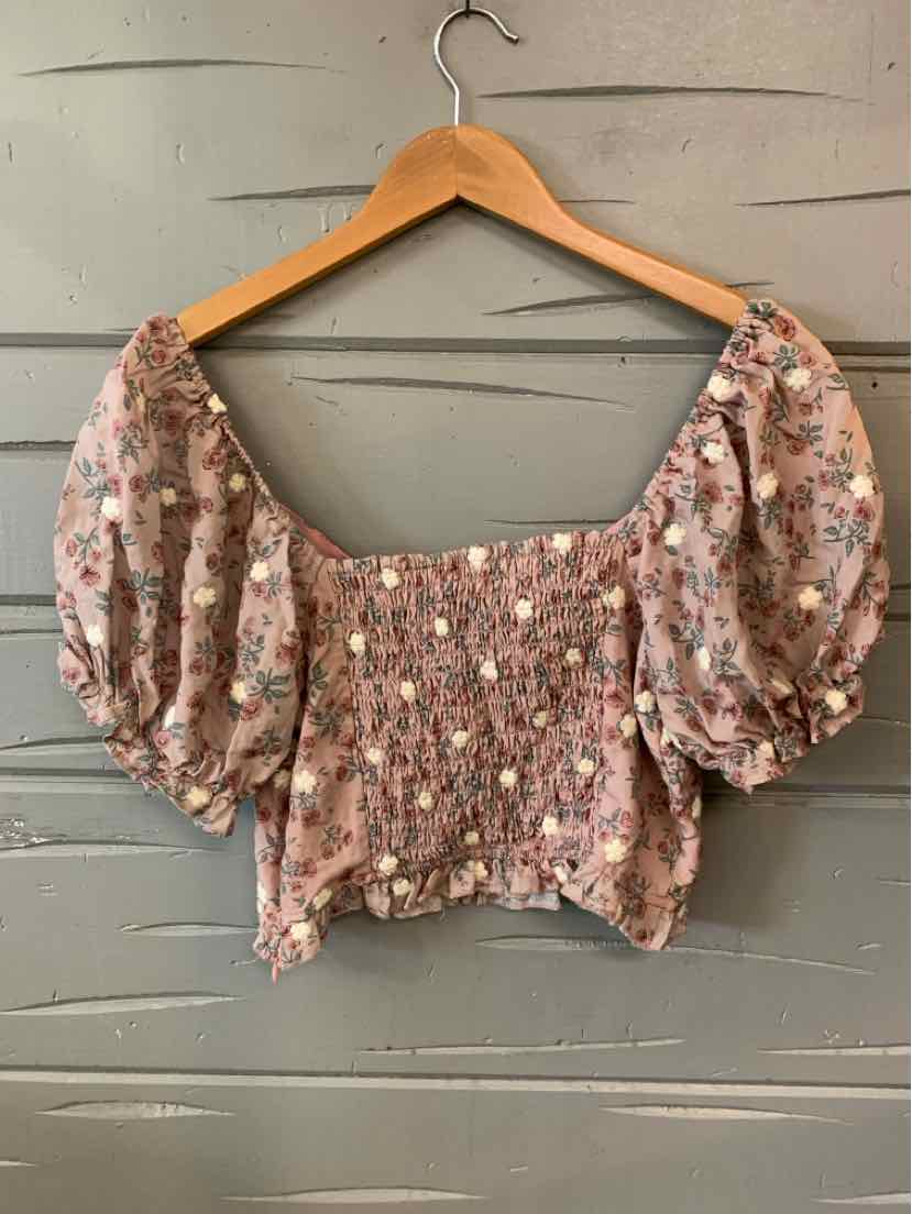 Pink floral smocked crop top with puffed sleeves and square neckline.