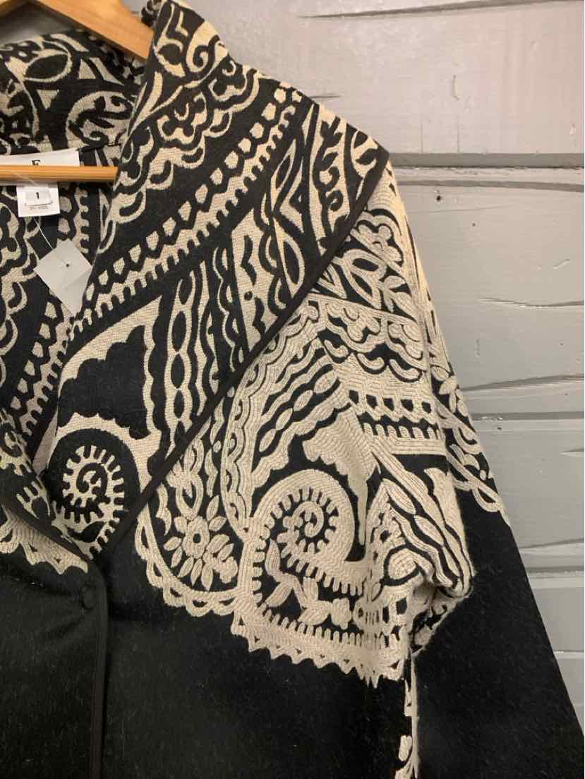 Black blouse with large intricate beige paisley embroidery on shoulder and sleeve.