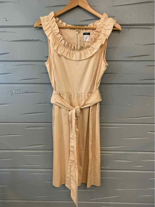 Tan sleeveless dress with ruffled neckline and fabric belt tied at waist, size 8.