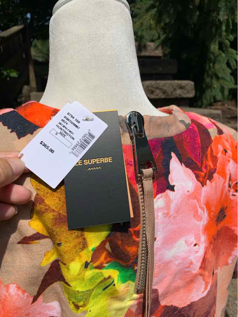 Floral multicolor jacket with silver front zipper and round neckline, size small.
