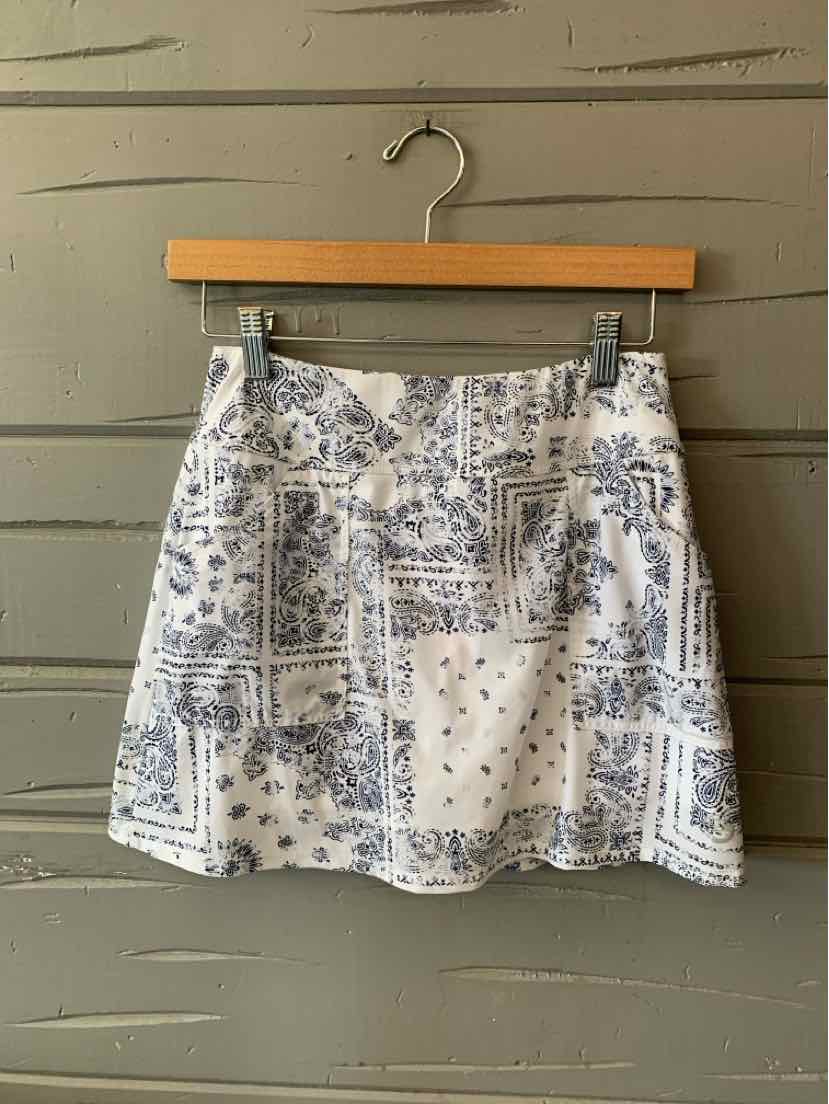 White mini skirt with blue paisley print and subtle patchwork design, lightweight fabric.