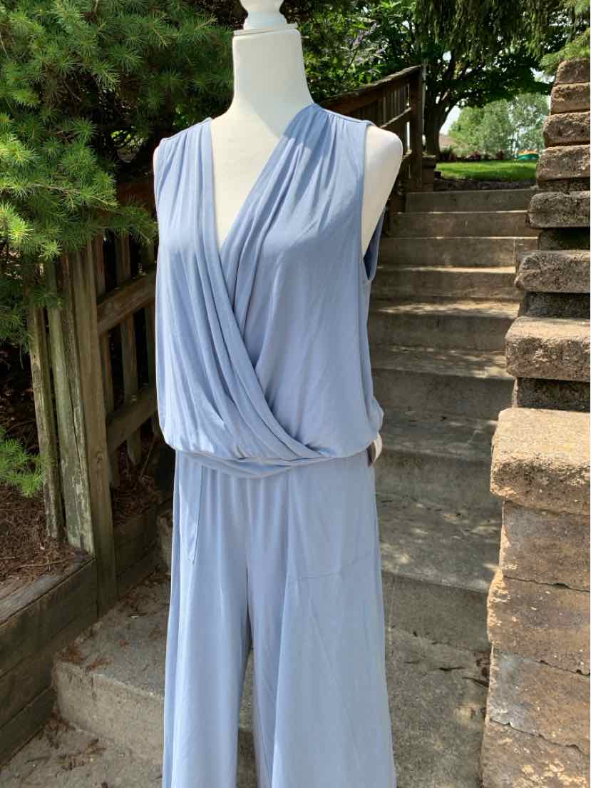Light blue sleeveless jumpsuit with a wrap-style V-neck and elastic waistband displayed outdoors on a mannequin.