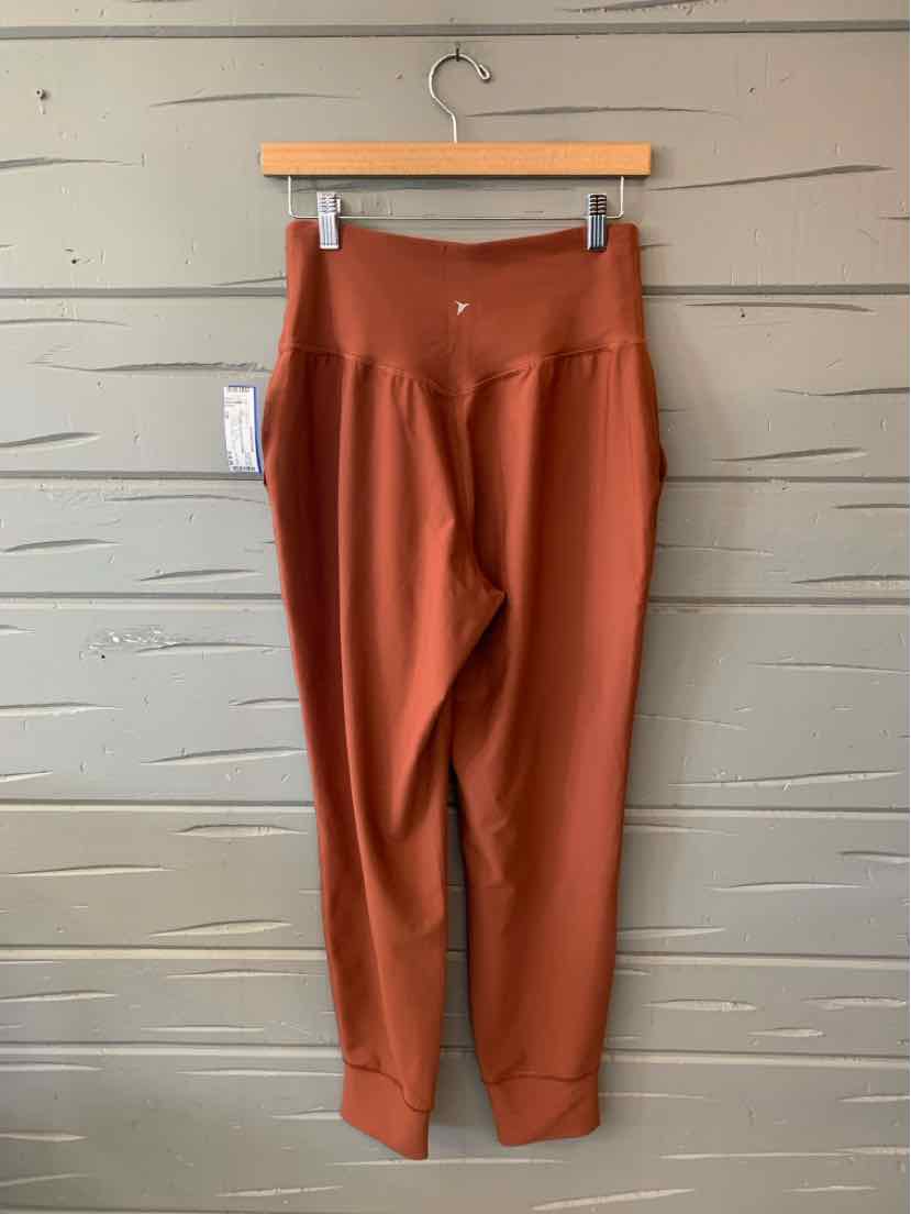 Rust-colored Old Navy women's slim-fit pants with a smooth finish, belt loops, and tapered legs.