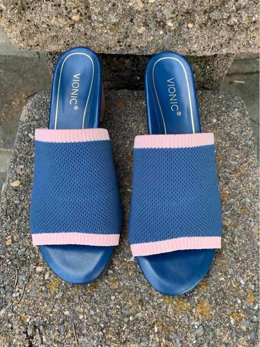 Blue slip-on sandals with textured fabric upper and light pink trim, cushioned footbed with Vionic logo.