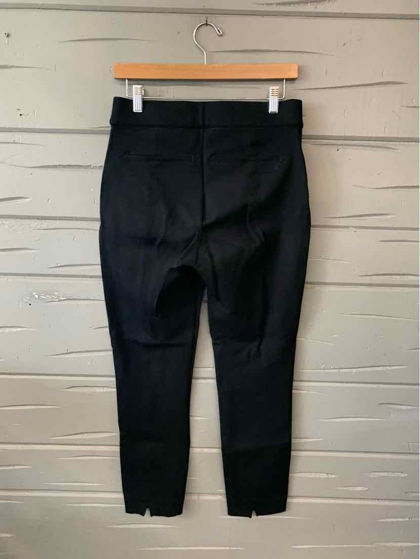 Black high-waisted shaping leggings with flat seams and ankle-length cut hanging on wooden hanger.