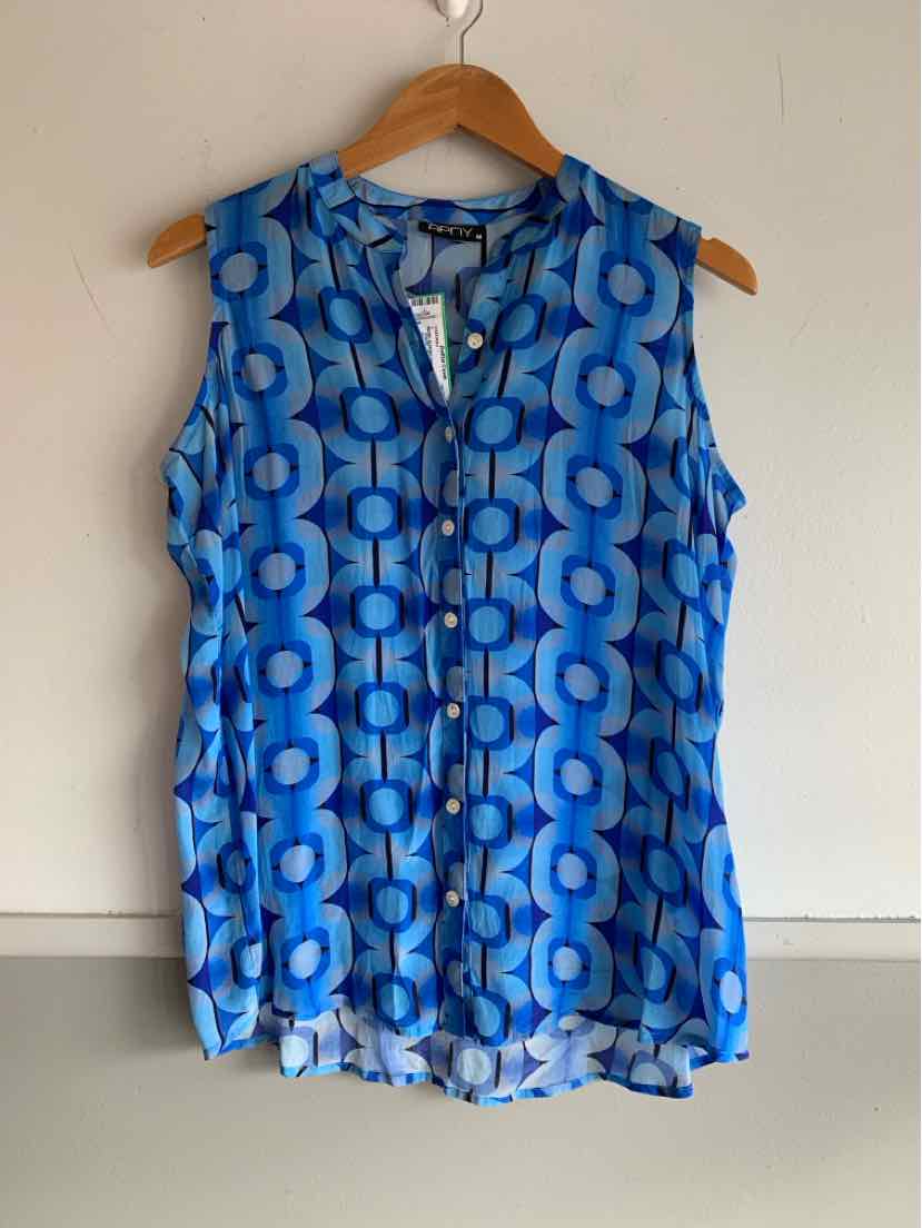 Sleeveless blue blouse with geometric circular pattern and button-front detail hanging on wooden hanger.