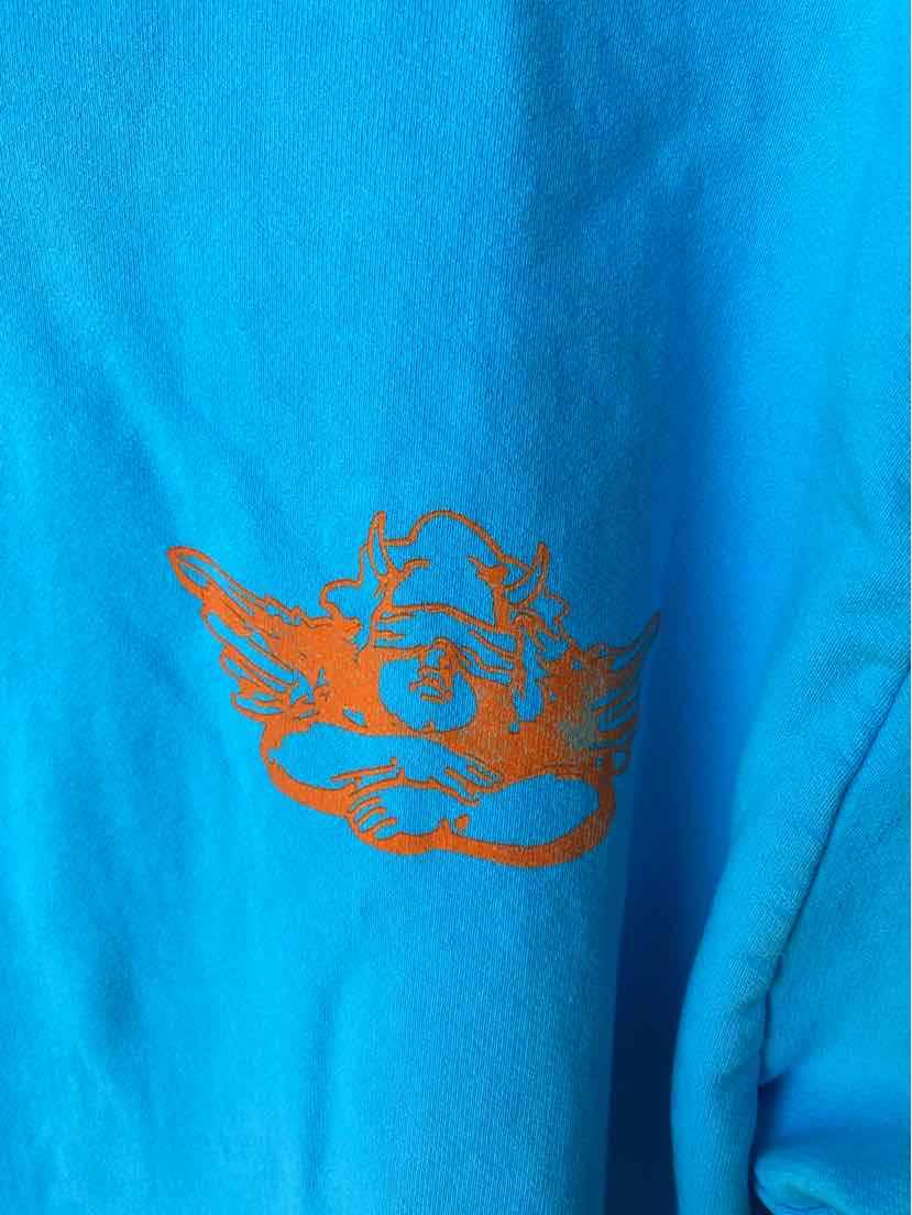 Bright blue fabric with an orange graphic of a cartoonish face wearing a cap and sunglasses.