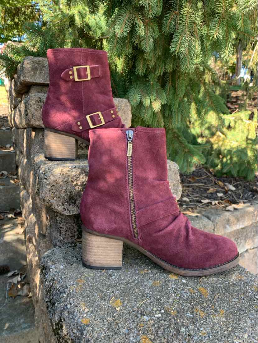 Burgundy suede mid-calf boots with side zippers, gold-tone buckle straps, and stacked block heels.