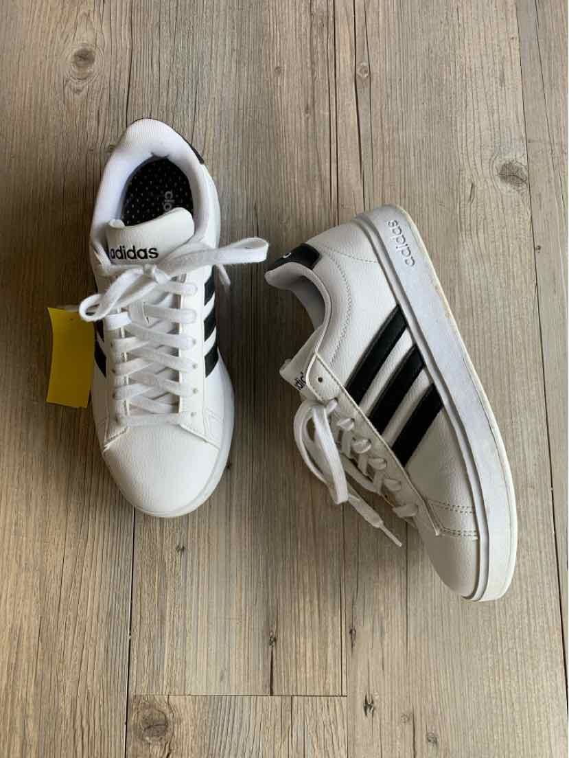 White Adidas sneakers with black stripes, lace-up closure, and rubber sole, size 7.5.
