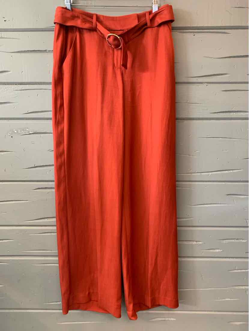 High-waist burnt orange wide-leg pants with fabric belt and D-ring buckle.