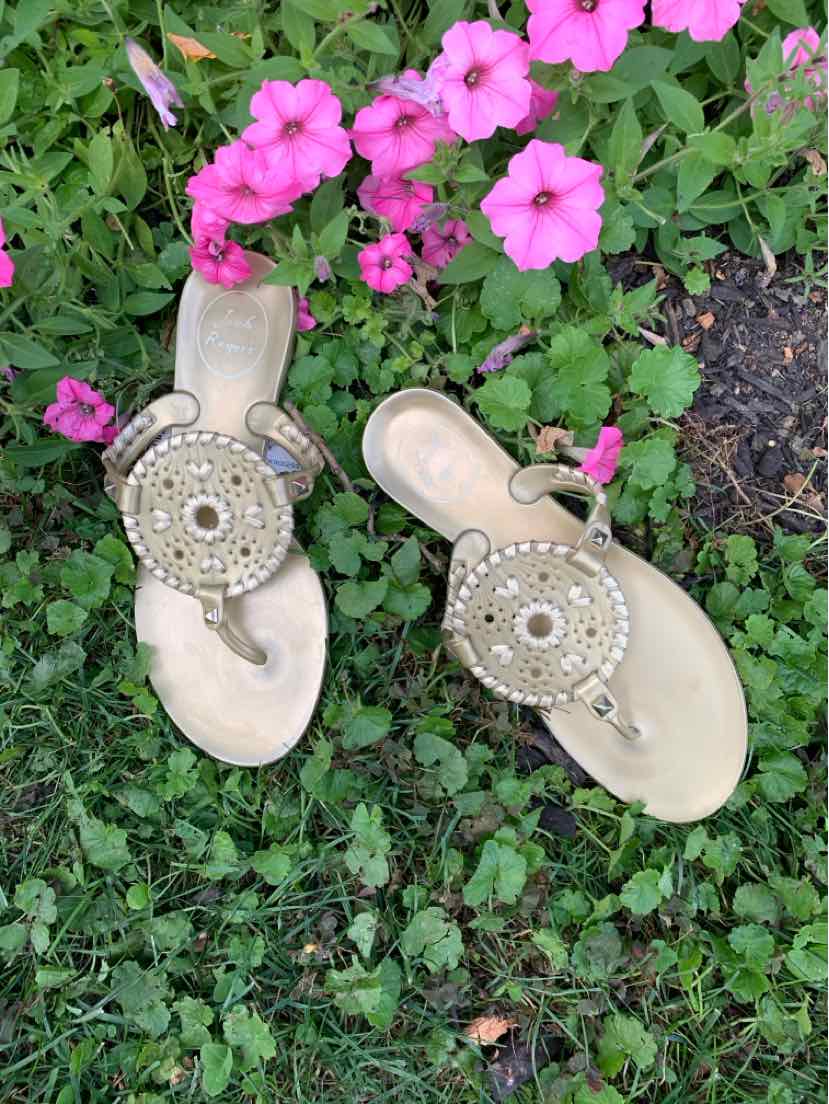 Gold metallic flat sandals with circular beaded medallion accents and thong straps, size 6.