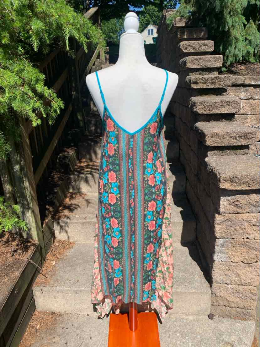 Floral print sleeveless midi dress with thin straps and multicolor vertical stripes.