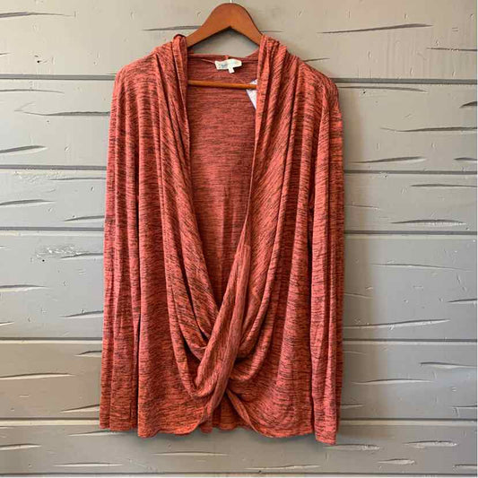 Orange long-sleeve women's casual top with draped front hanging on wooden hanger.