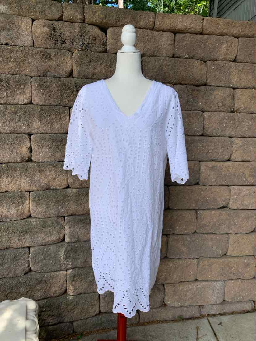 White eyelet dress with V-neck, half sleeves, and scalloped hem on mannequin.