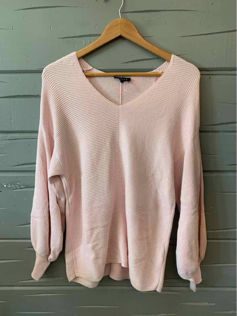 Light pink long-sleeve sweater with a V-neck and ribbed cuffs on wooden hanger.
